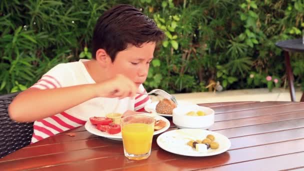 Barn äter frukost i trädgården — Stockvideo