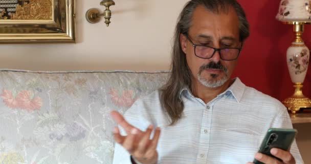 Portrait Middle Aged Hispanic Man Sitting Sofa Using Smartphone Home — Stock Video