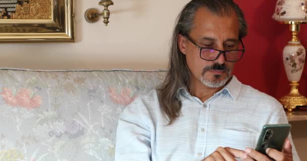 Portrait Middle Aged Hispanic Man Sitting Sofa Using Smartphone Home — Stock Video