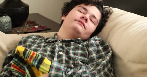 睡梦中的少年穿着睡衣躺在沙发上打呵欠 — 图库视频影像