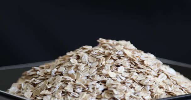 Pile Uncooked Rolled Oats Rotating Black Background — Stock Video