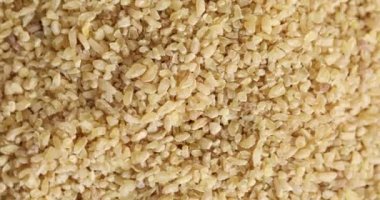 Ham organik bulgur taneleri dönüyor.