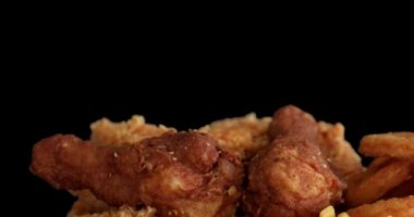 Lezzetli patates kızartması ve hardallı çıtır tavuk nuggetları ve siyah arka planda ketçap.
