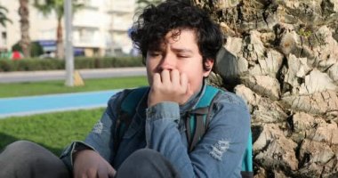 Dışarıdaki kameraya bakarken ciddi şekilde rencide olmuş genç bir çocuk.