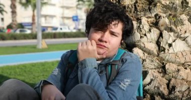 Dışarıdaki kameraya bakarken ciddi şekilde rencide olmuş genç bir çocuk.