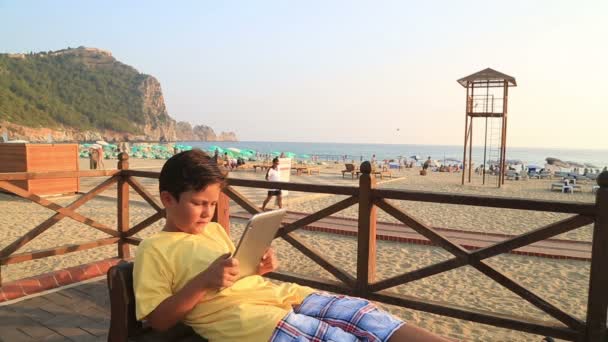 Child with digital tablet on the beach — Stock Video