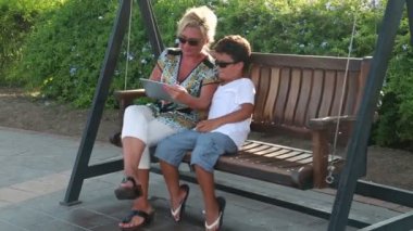 Anne ve oğlu sallanan ve dijital tablet 3 kullanma