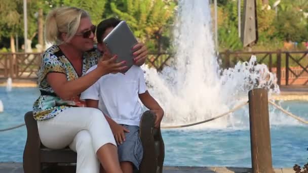 Mère et fils assis sur un banc de parc — Video