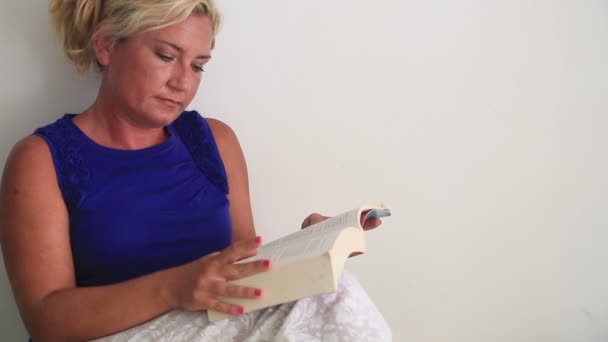 Een vrouw die een boek leest — Stockvideo