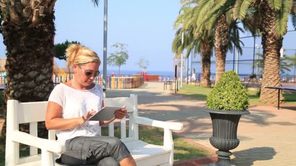 Mujer usando tableta digital en el parque — Vídeos de Stock