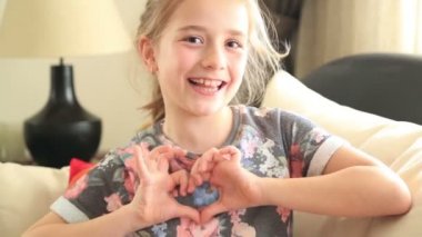 Küçük kız bir kalp sembolü yapma