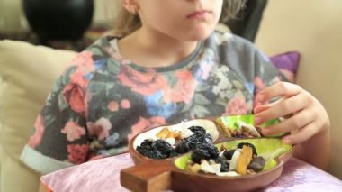 Kurutulmuş meyve yiyen küçük kız