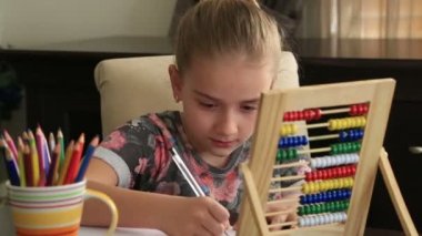 Küçük kız çalışma evde ve kameraya gülümseyen