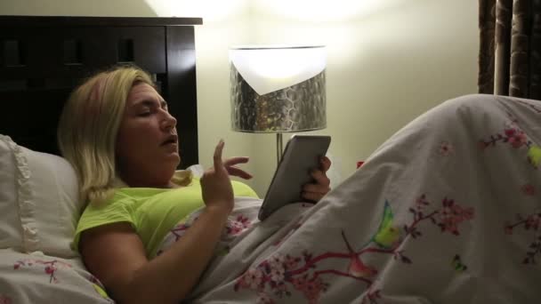 Sleeply 여자 침대에서 디지털 태블릿을 사용 하 여 — 비디오