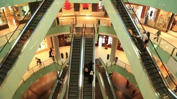 Personas en escaleras mecánicas en el centro comercial — Vídeo de stock