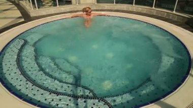 Kadın dışarıda jakuzide dinleniyor.