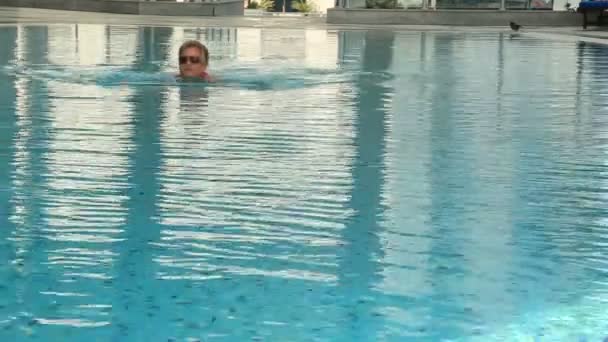 Женщина плавает в бассейне — стоковое видео
