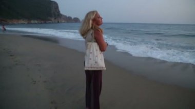 Kumsalda yürüyen bir kadın