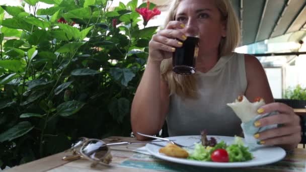 Mujer comiendo ensalada y carne en restaurante — Vídeo de stock