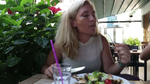 レストランでサラダや肉を食べる女性 — ストック動画