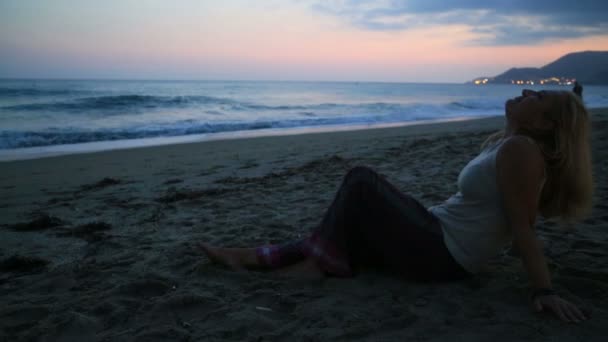 Nő ül a strandon — Stock videók