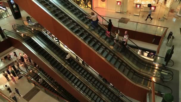 Des gens sur un escalier roulant dans un centre commercial — Video