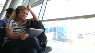 Havaalanında 2 dijital tablet kullanan kadın