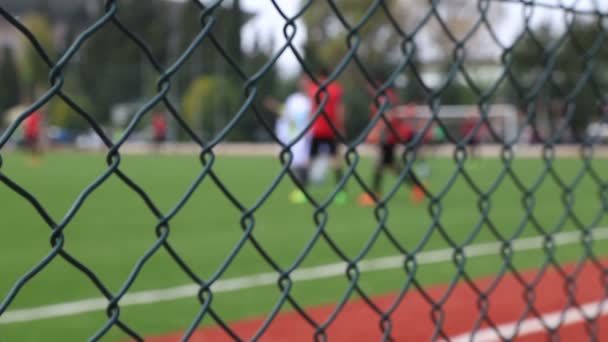 Jogo de futebol por trás da cerca — Vídeo de Stock