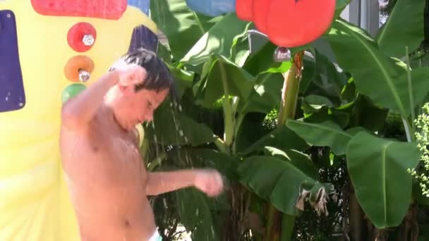 Gelukkig kind nemen van een koude douche in een waterpark — Stockvideo