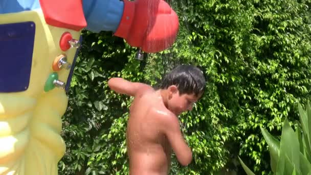 Barn tar en kalldusch i en vattenpark — Stockvideo