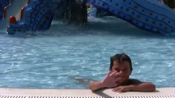 Niño sonriendo a la cámara en el parque acuático — Vídeo de stock