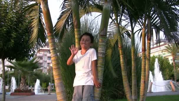 Lindo niño sonriendo y saludando la mano — Vídeos de Stock