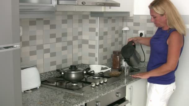 Mulher fazendo seu chá da manhã na cozinha — Vídeo de Stock