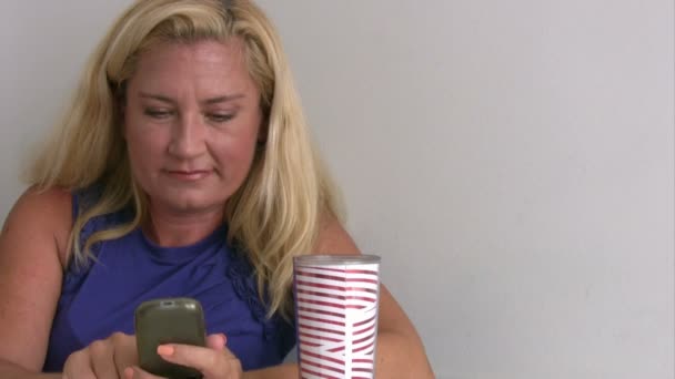 Frau benutzt Smartphone und trinkt Kaffee — Stockvideo