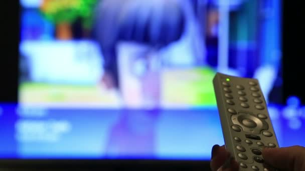 Mão muda os canais no controle remoto da TV — Vídeo de Stock