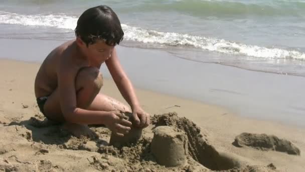 Barn leker med sand på stranden — Stockvideo