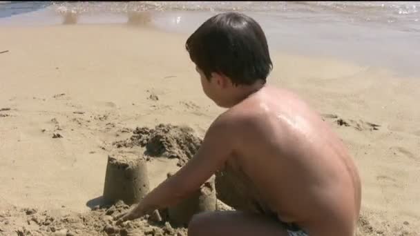 Kind spelen met zand op het strand — Stockvideo