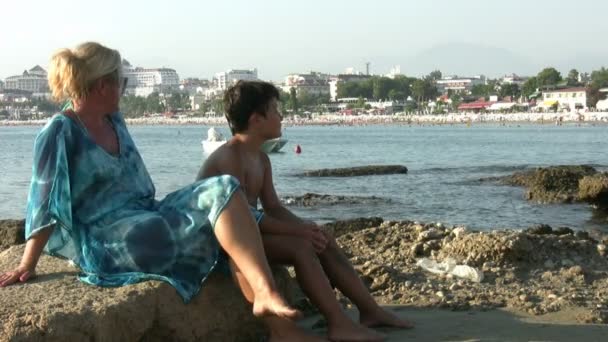 母亲和儿子坐在海滩和谈 — 图库视频影像