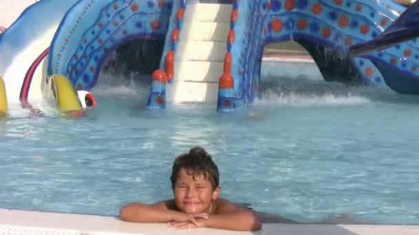 Niño en aqua park sonriendo a una cámara — Vídeos de Stock