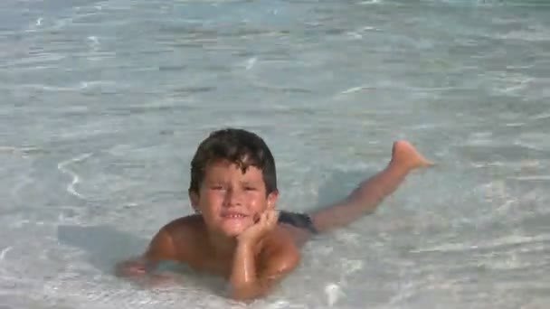 Niño en la piscina sonriendo a una cámara — Vídeo de stock