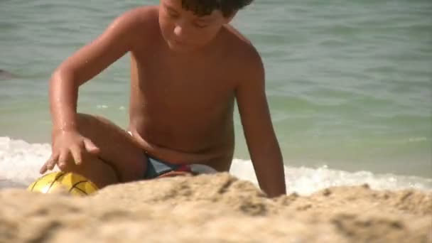 Niño jugando en la playa — Vídeo de stock