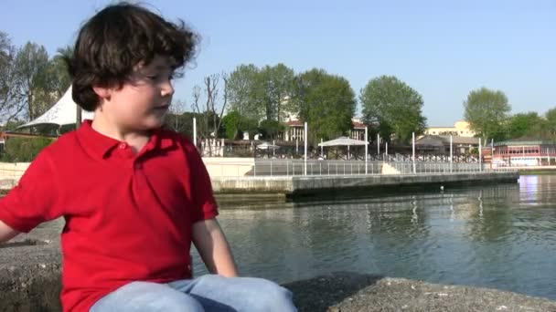 Μικρό αγόρι που ρίχνουν πέτρες στη θάλασσα — Αρχείο Βίντεο
