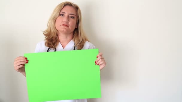 Triest vrouw vasthouden aan een groen scherm — Stockvideo