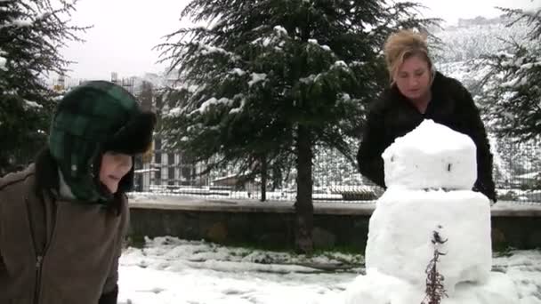 Μητέρα και γιος με χιονάνθρωπος — Αρχείο Βίντεο