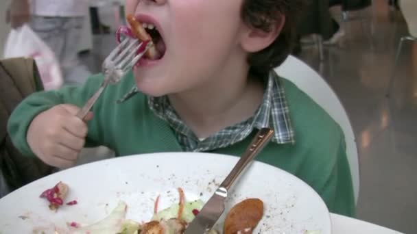Kleiner Junge beim Mittagessen in einem Restaurant — Stockvideo