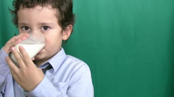 Lille dreng drikker mælk på grøn screeen – Stock-video