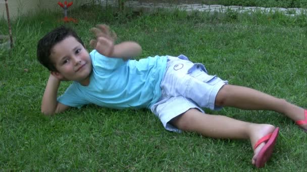 Niño pequeño relajándose en el jardín — Vídeos de Stock