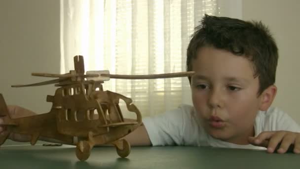 Kleine jongen spelen houten helikopter — Stockvideo