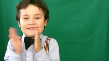 Yeşil bir ekran önünde alkışlar çocuk