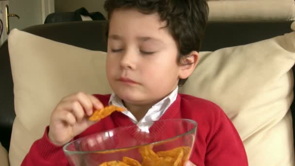 Ung pojke äta potatis Chisps — Stockvideo